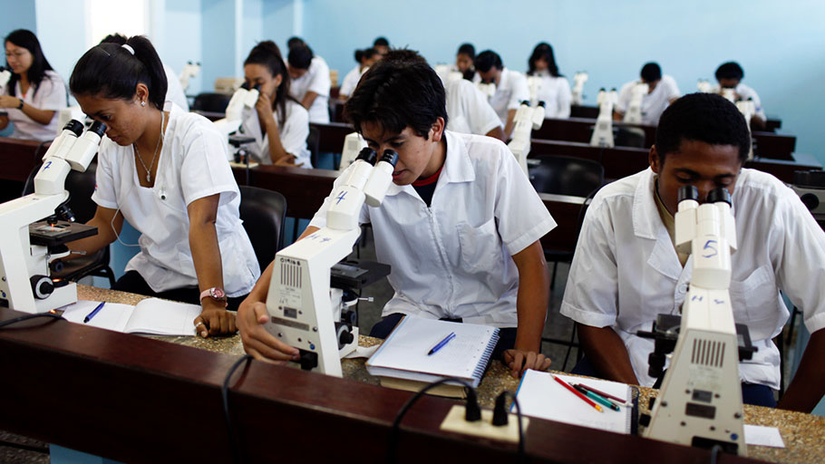 Medicine students look through microscopes at a laboratory of the Latin American School of Medicine in Havana.