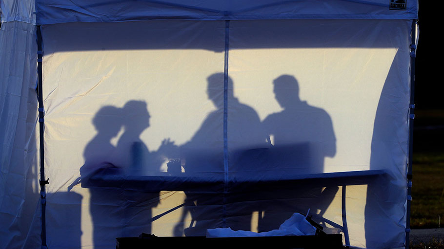 Medical personnel are silhouetted against the back of a tent at a coronavirus test site in Tampa, Florida. 