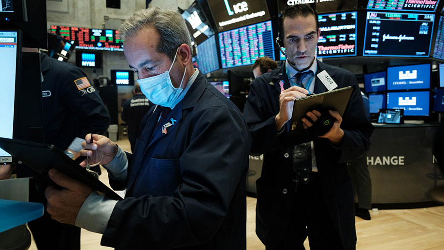 Traders, some in medical masks, work on the floor of the New York stock exchange last week. Traders are now working remotely.