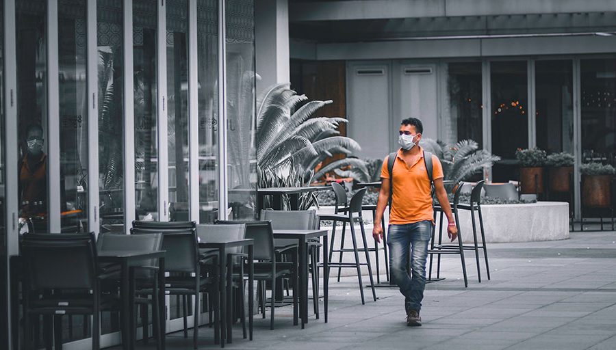 Tourists wearing mask on an empty street during COVID 19 pandemic lockdown in Singapore. Bars are closed.