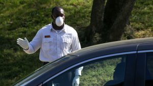 A first responder greets patients waiting in their cars Monday to enter a coronavirus testing center at United Medical Center, the sole hospital in Washington’s Ward 8.