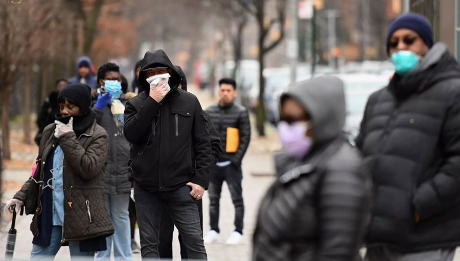 People who believe they have COVID-19, and who meet the criteria, wait in line to be pre-screened for the coronavirus outside of the Brooklyn Hospital Center on March 20 in Brooklyn, New York