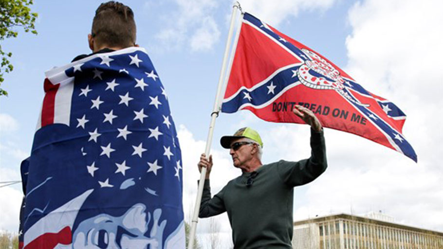 A protester holds a flag that combines a Gadsden flag from the American Revolution with a Confederate flag during a demonstration against Washington state's stay-home order at the state capitol in Olympia, Wash., on April 19, 2020.