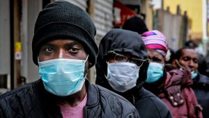 People waiting for a distribution of masks and food in Harlem, New York City.