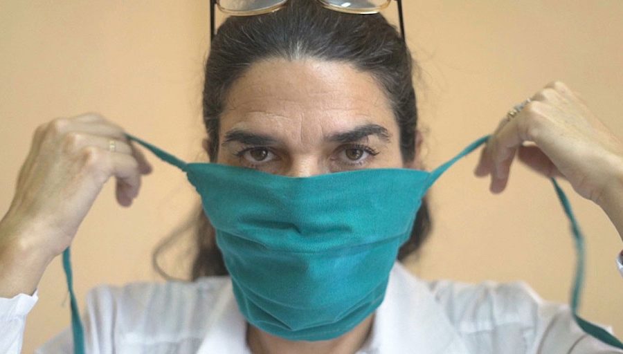 Dr. Liz Caballero putting on her mask before going door-to-door to check on residents in the El Carmelo municipality of Havana, Cuba, March 31, 2020