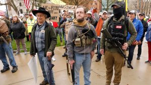 Armed protesters provide security as demonstrators take part in an "American Patriot Rally," on the steps of the Michigan State Capitol in Lansing, on April 30, 2020