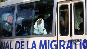 Haitian migrants ride on a bus after arriving on a deportation flight from the United States, amidst the outbreak of the coronavirus disease (COVID-19), in Port-au-Prince, Haiti.