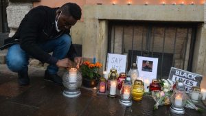 A man lights a candle in front of the US Consulate in Krakow on Sunday, May 31.