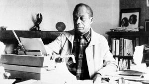 American novelist James Baldwin sits in front of his typewriter in the study of his home in St. Paul de Vence, in southern France, on March 21, 1983.