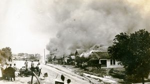 Smoke rises from damaged properties after the Tulsa Race Massacre in Tulsa, Oklahoma June 1921.