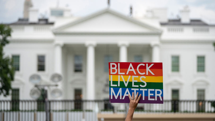 A protester holds a Black Lives Matter sign in front of the White House.