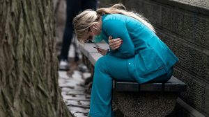 A healthcare worker sits on a bench near Central Park in New York City, on Mar. 30, 2020.