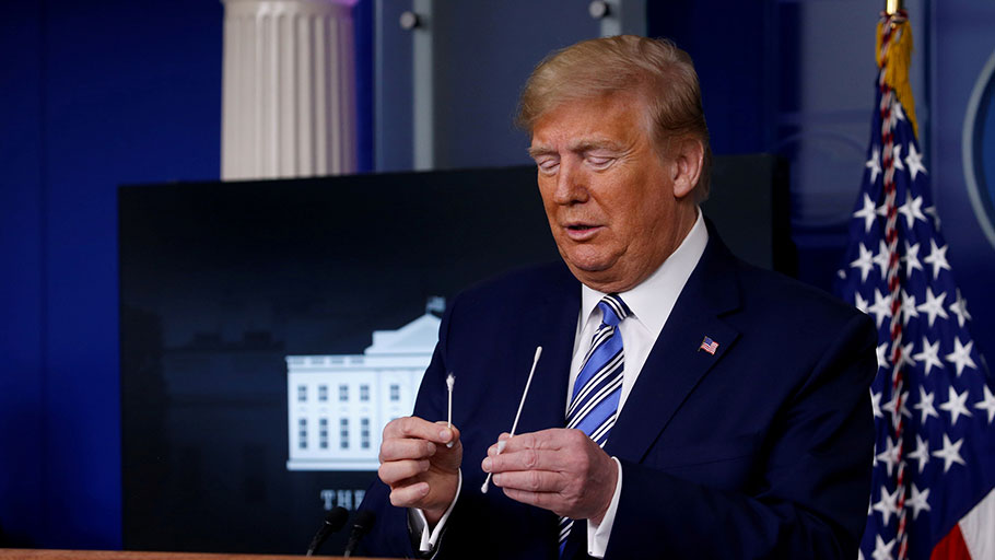President Donald Trump compares a swab for coronavirus disease testing with regular cotton swabs during the daily coronavirus task force briefing at the White House, on Apr. 19, 2020.