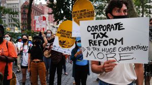 People participate in a "March on Billionaires" event on July 17 in New York City. The march called on Governor Andrew Cuomo to pass a tax on billionaires and to fund workers excluded from unemployment and federal aid programs