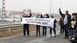 About 100 people in cars and on foot made their way through the north end of Halifax Saturday to protest the continued lack of reparations for the expropriation and demolition of Africville in the 1960s.