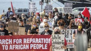 Marchers walk in downtown San Diego during the “March for Reparations to African People” which is a national day of political action coordinated by the Uhuru Solidarity Movement on Saturday, Oct. 17, 2020.