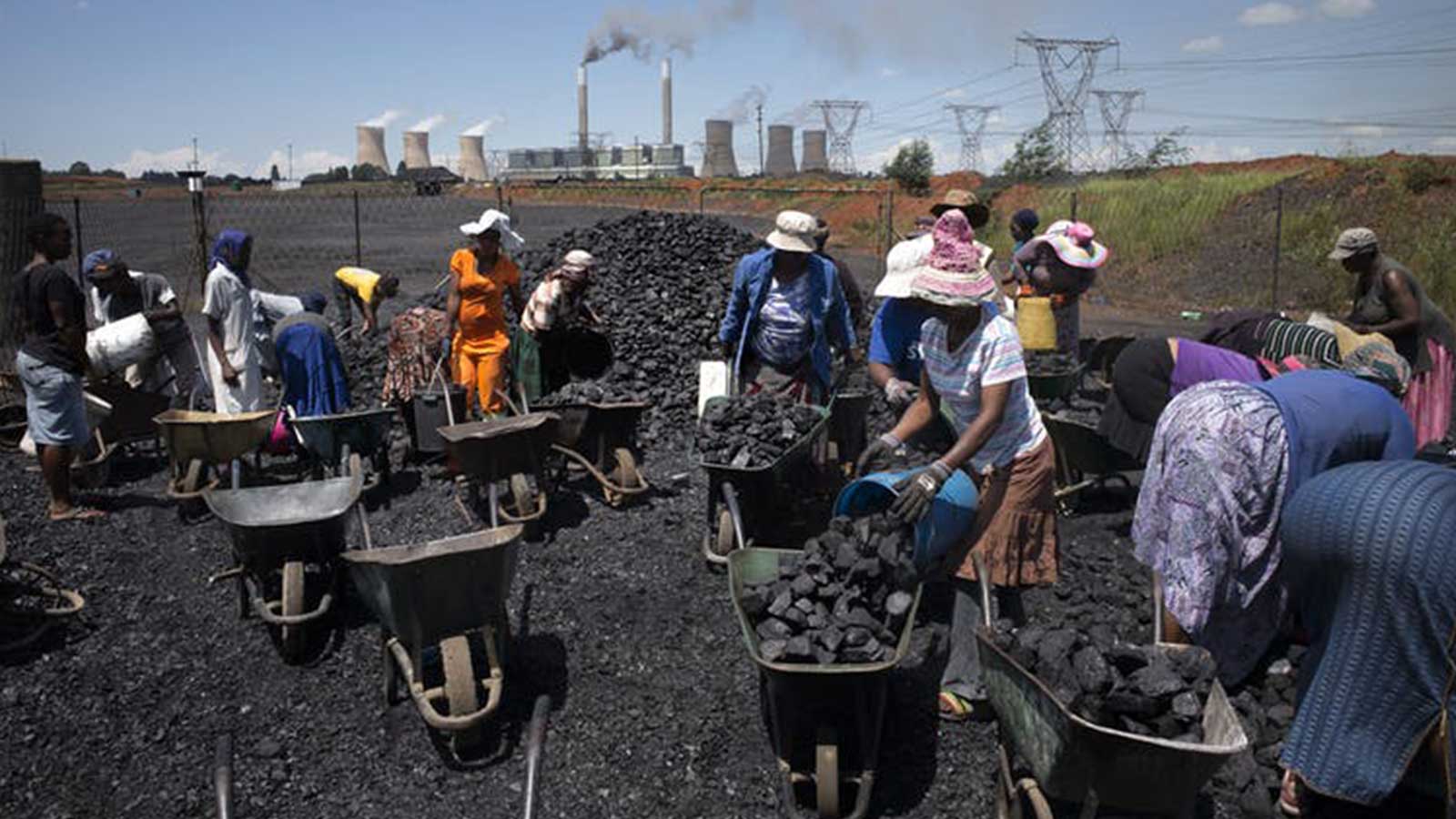 Women in South Africa fill wheelbarrows with free coal
