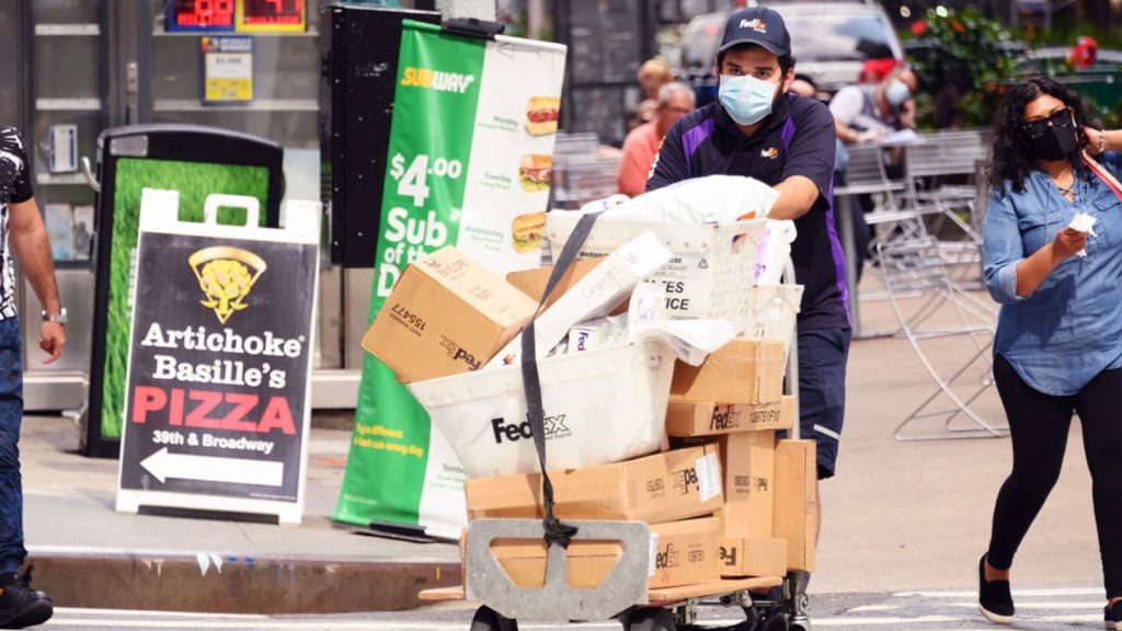 A FedEx worker delivers packages in midtown New York