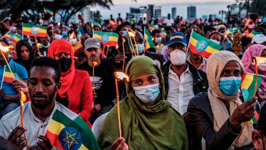 People hold candles and Ethiopian flags in Addis Ababa, Ethiopia, on November 3, 2021 during a memorial service for the victims of the Tigray conflict. The memorial was organised by the city administration.