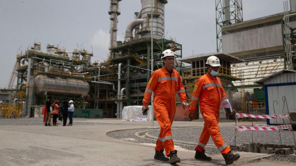 Workers walk past the newly inaugurated Dangote fertilizer plant in Lagos, Nigeria.