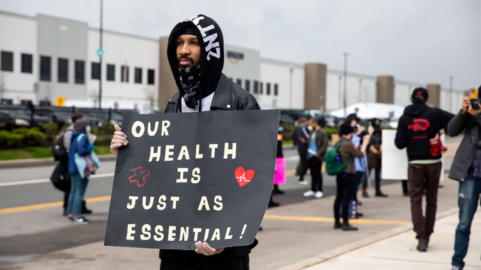 Chris Smalls holds a sign during a protest outside an Amazon facility on Staten Island on May 1, 2020, after he was fired by the company.