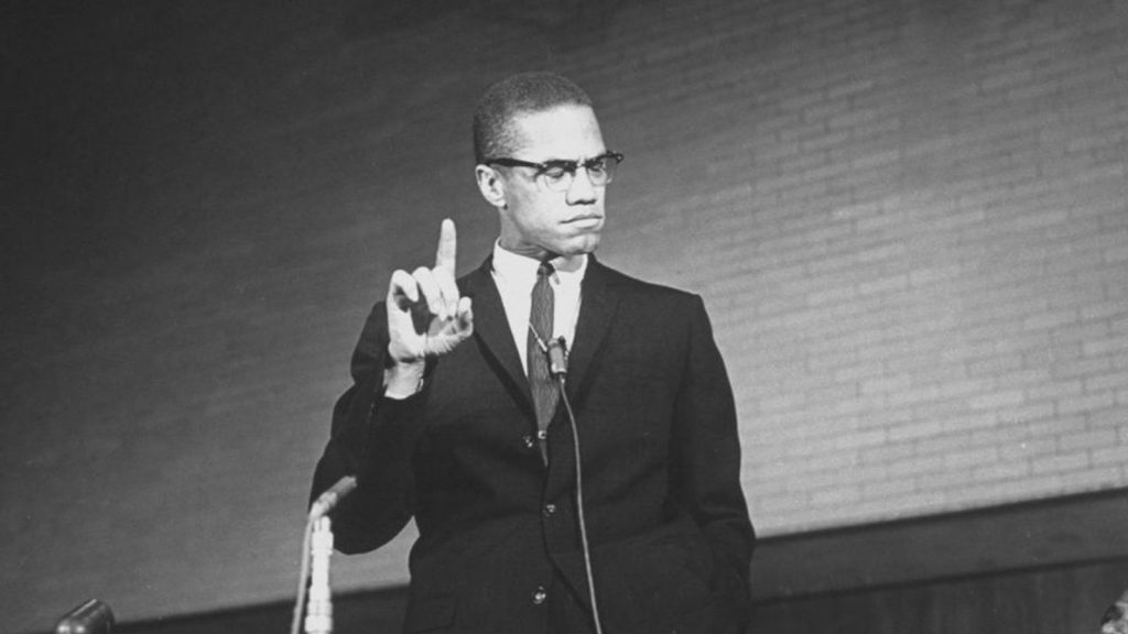 Malcolm X reacts during a speech at a rally.