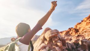 Black woman on mountain with fist in air