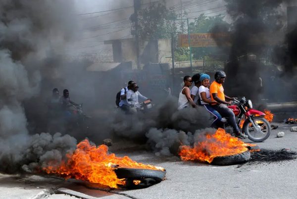 Motorcycle drivers passing through a burning roadblock as anger mounted over fuel shortages that have intensified as a result of gang violence this month in Port-au-Prince.