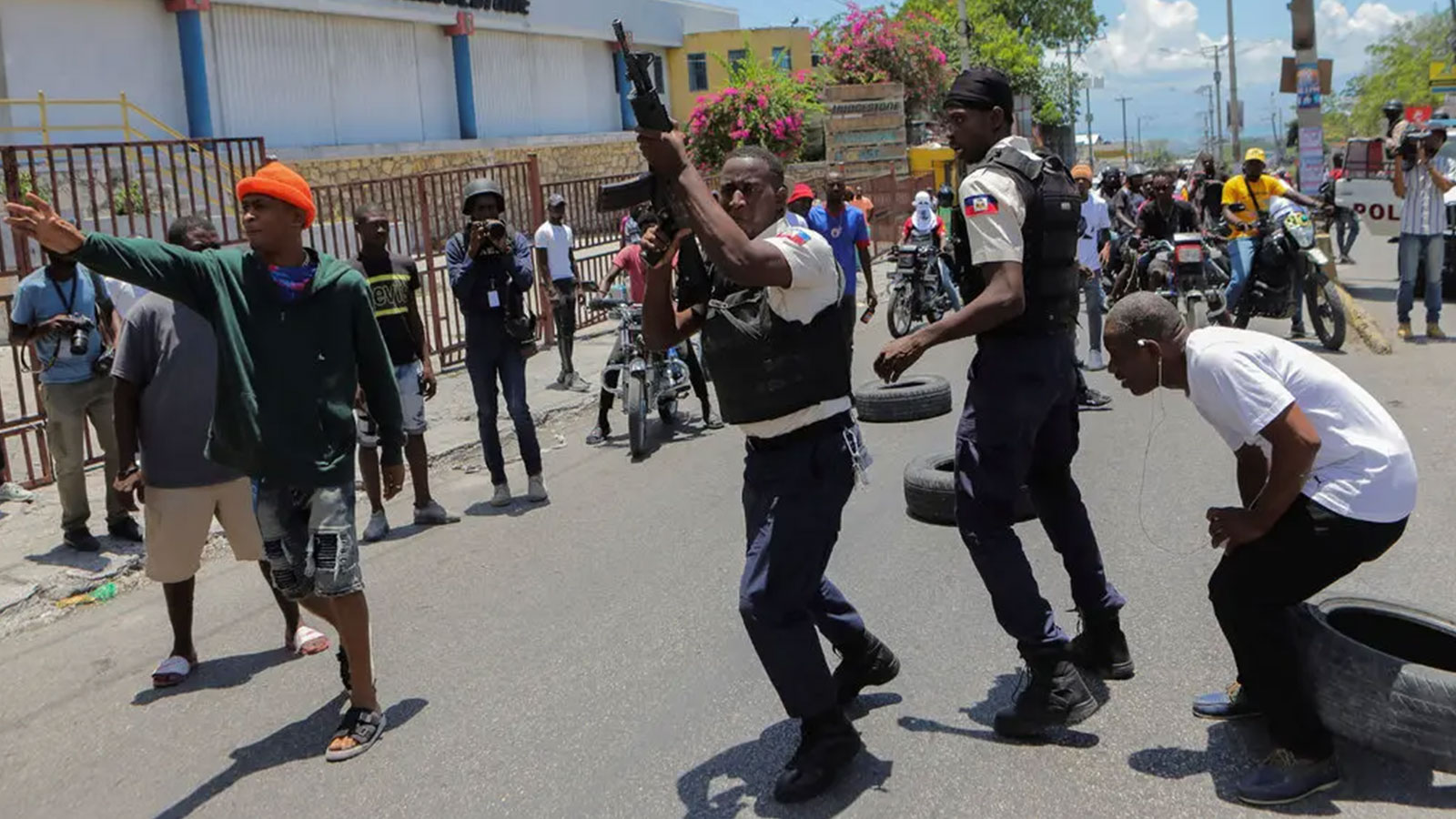 A police officer raised a rifle to deter protesters in Port-au-Prince. 