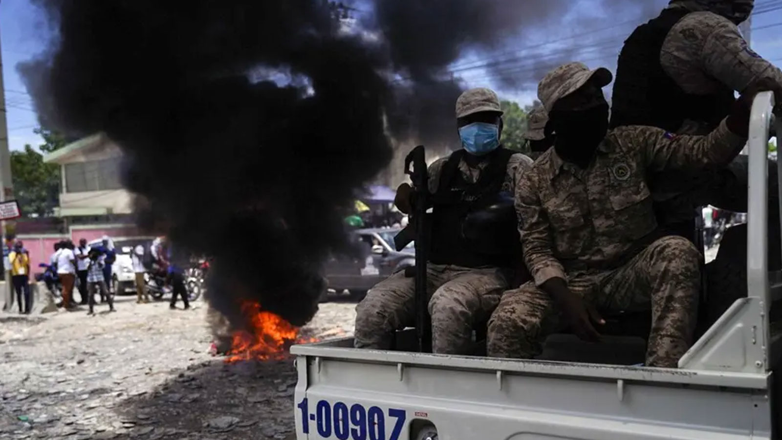Haitian police passed a burning barricade set up by protesters. The police are often overwhelmed by gangs who have access to more powerful weapons.