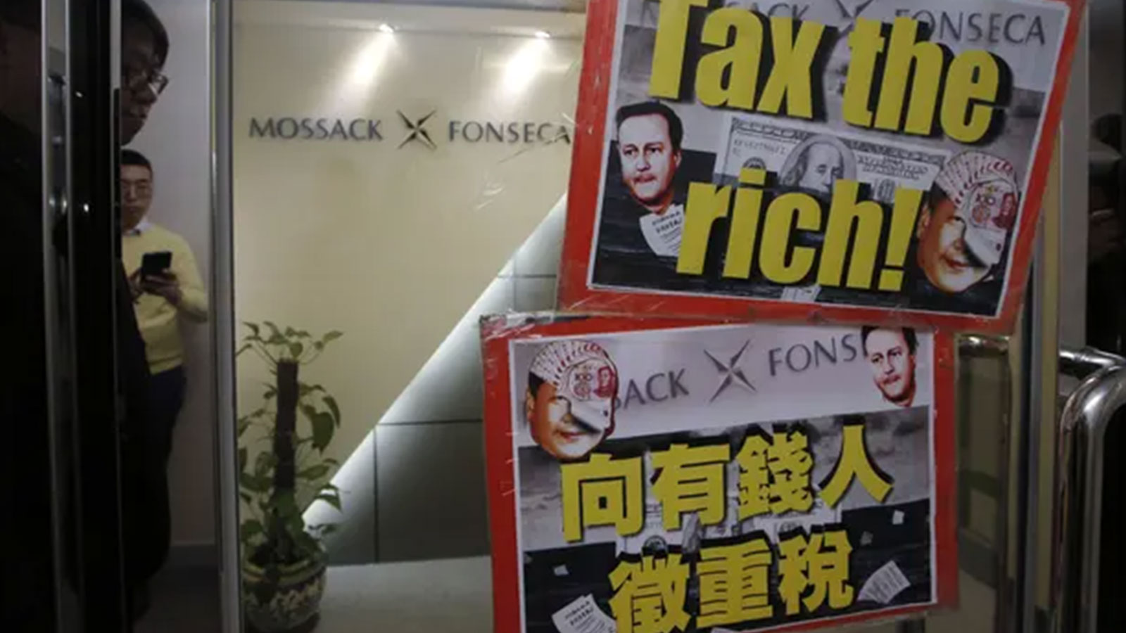 Placards featuring the portraits of Chinese Communist party leader Xi Jinping and then British prime minister, David Cameron at the entrance of the regional head office of Panama-based law firm Mossack Fonseca in Hong Kong, April 2016.