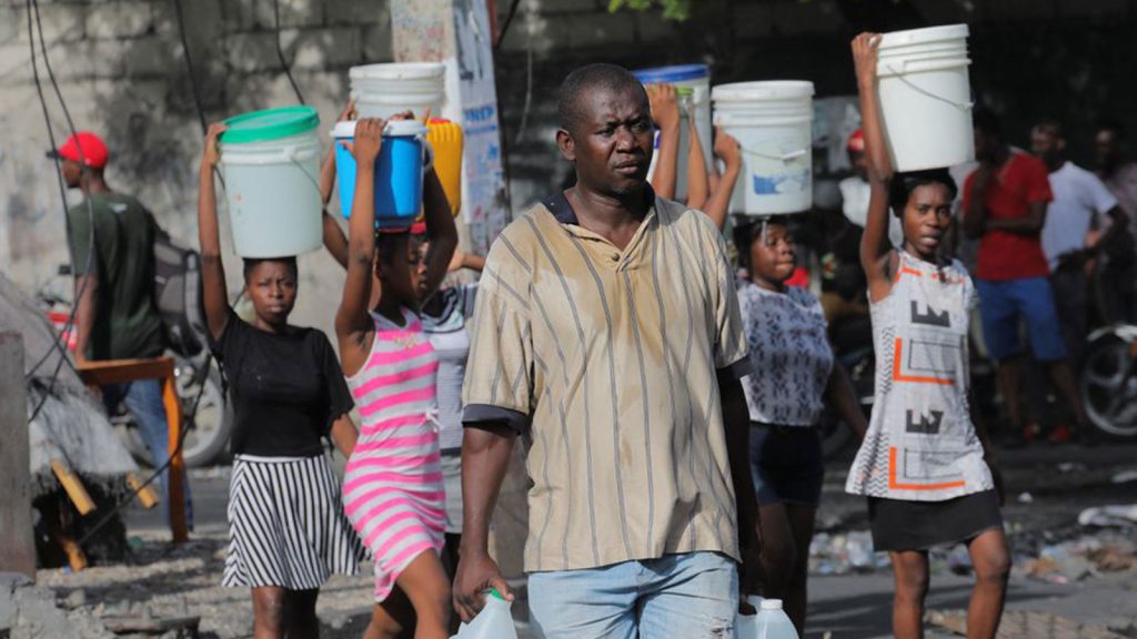 A man carries containers to fill with water amid water shortages due to daily protests against high gasoline prices and crime, and to stock up for Storm Fiona approaching in the Caribbean region, in Port-au-Prince, Haiti. September 17, 2022.