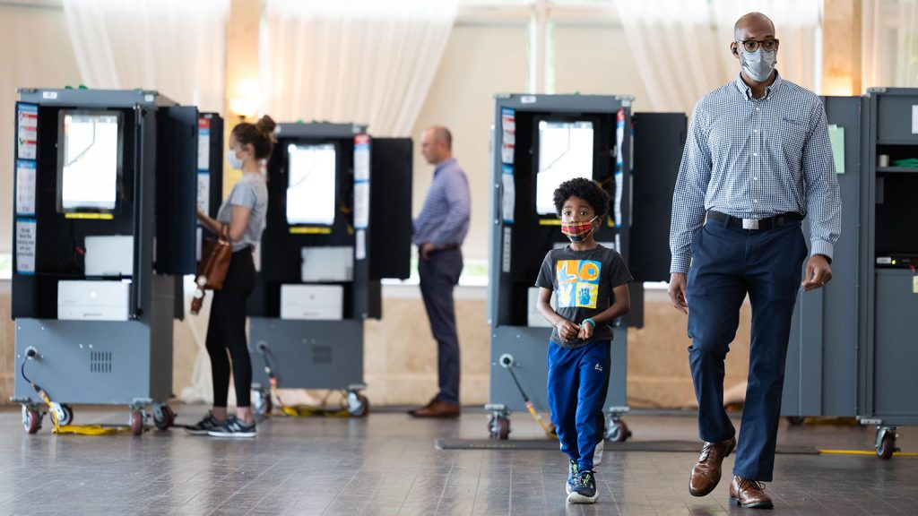 A Black man and his son leave a polling location in Atlanta after casting a vote in the Georgia primary election on May 24, 2022.