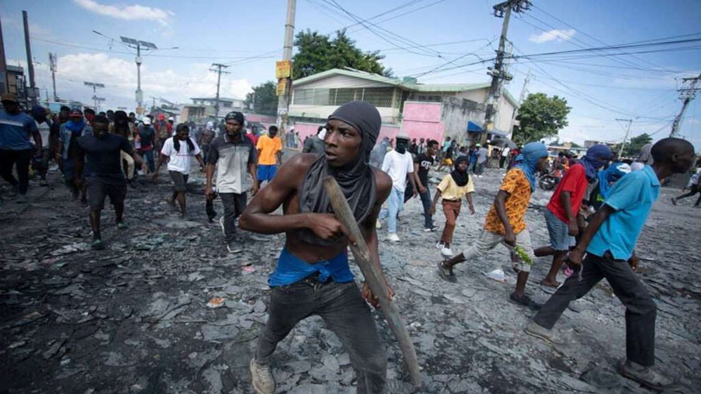 A protester carries a piece of wood simulating a weapon during a protest demanding the resignation of Prime Minister Ariel Henry, in the Petion-Ville area of Port-au-Prince, Haiti, October 3, 2022.