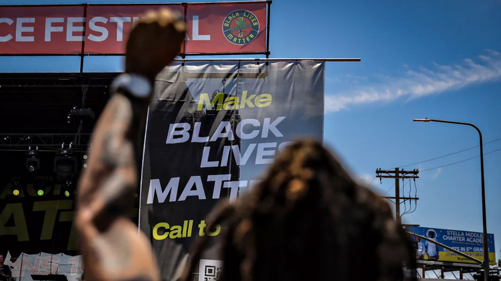 A man holds his fist in the air at the 10th anniversary Black Lives Matter Festival in Leimert Park on Saturday.
