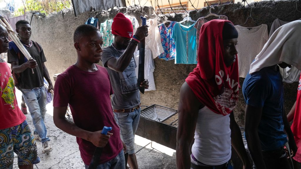 Men with machetes, part of “Bwa Kale,” an initiative to resist gangs from getting control of their neighborhood, walk in the Delma district of Port-au-Prince, Haiti, Sunday, May 28, 2023.