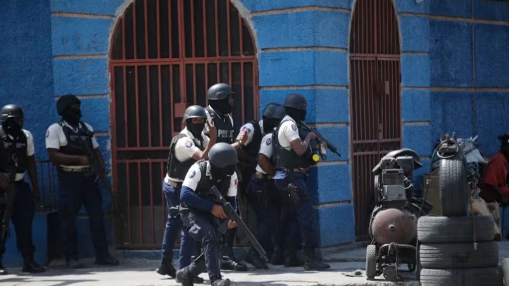 Police officers take cover during an anti-gang operation in the Lalue neighborhood of Port-au-Prince, Haiti, on March 3, 2023.
