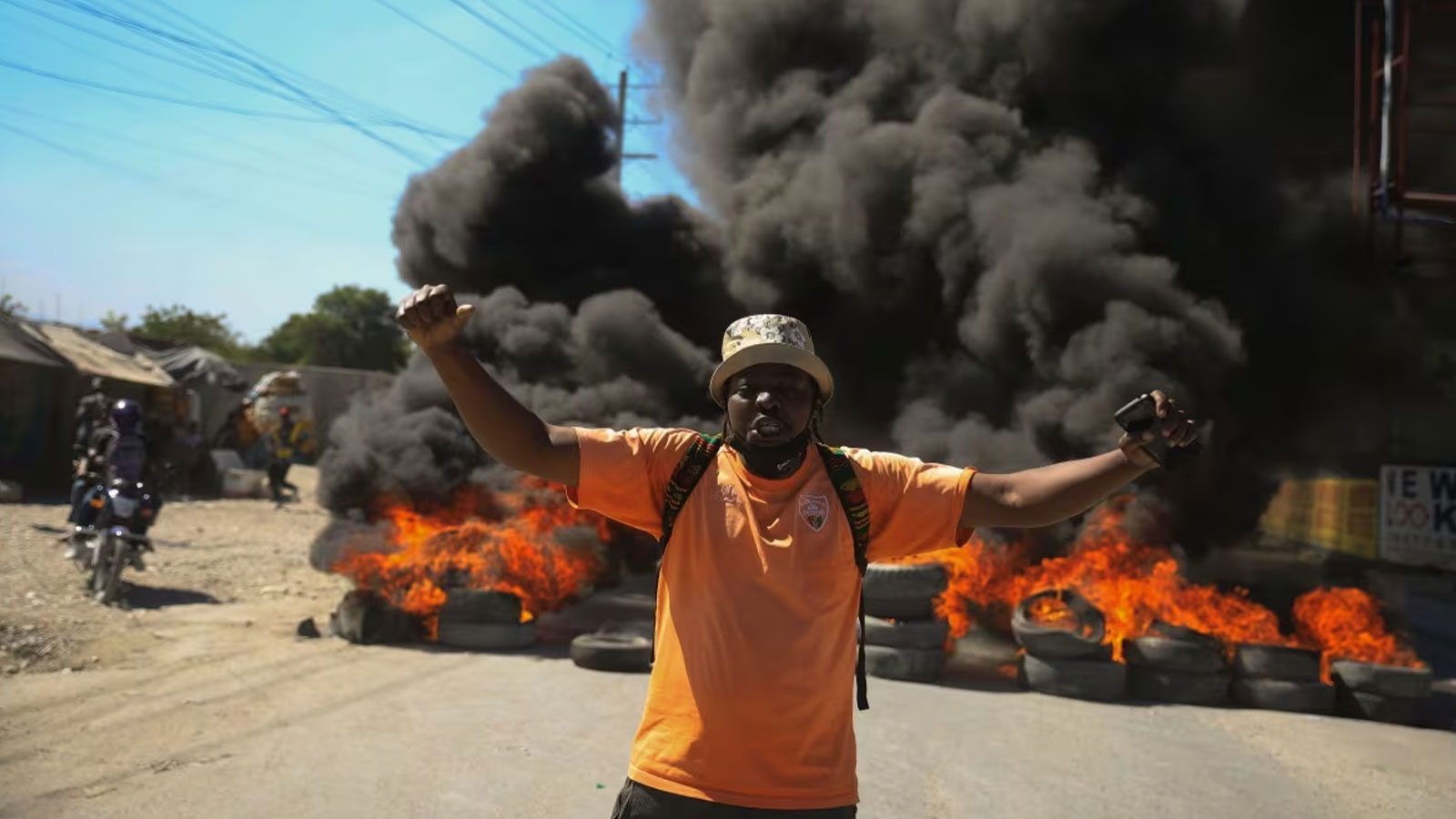 A protester shouts anti-government slogans by a burning barricade set up by members of the police to protest bad police governance in Port-au-Prince on Jan. 26, 2023.