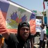A demonstrator holds up a Haitian flag at a protest of insecurity in Port-au-Prince on Aug. 7. Armed gangs control large sections of the capital and are spreading into the countryside.