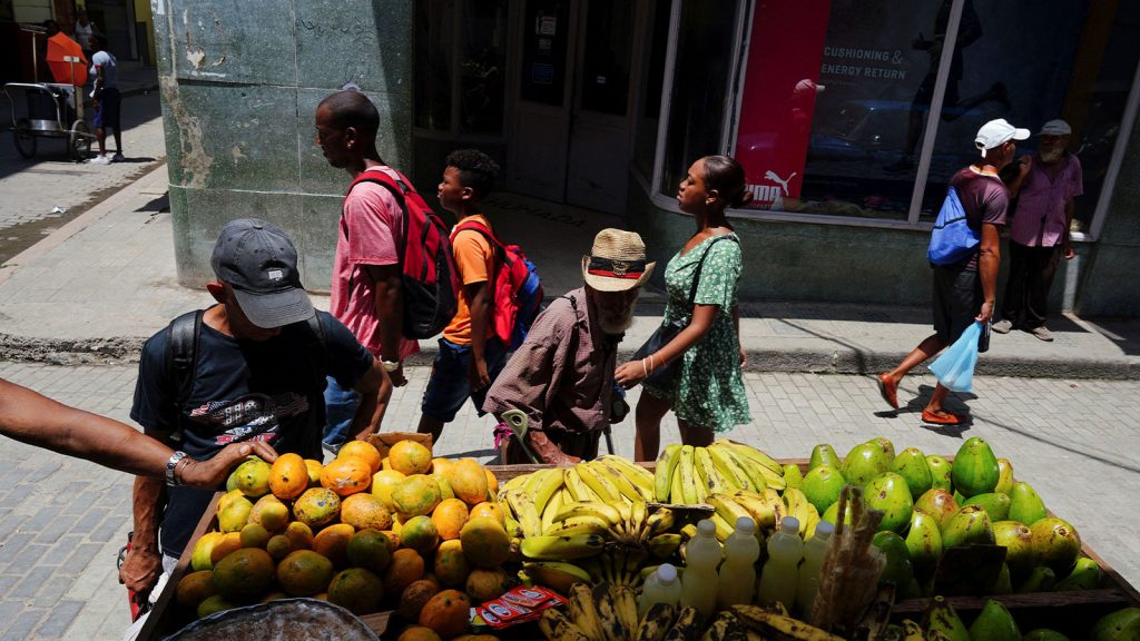 People check vegetables for sale on a cart in downtown Havana, Cuba, August 14, 2023.