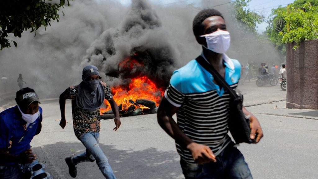 Men run next to burning tires during a protest demanding an end to gang violence, in Port-au-Prince, Haiti, on Aug. 14.