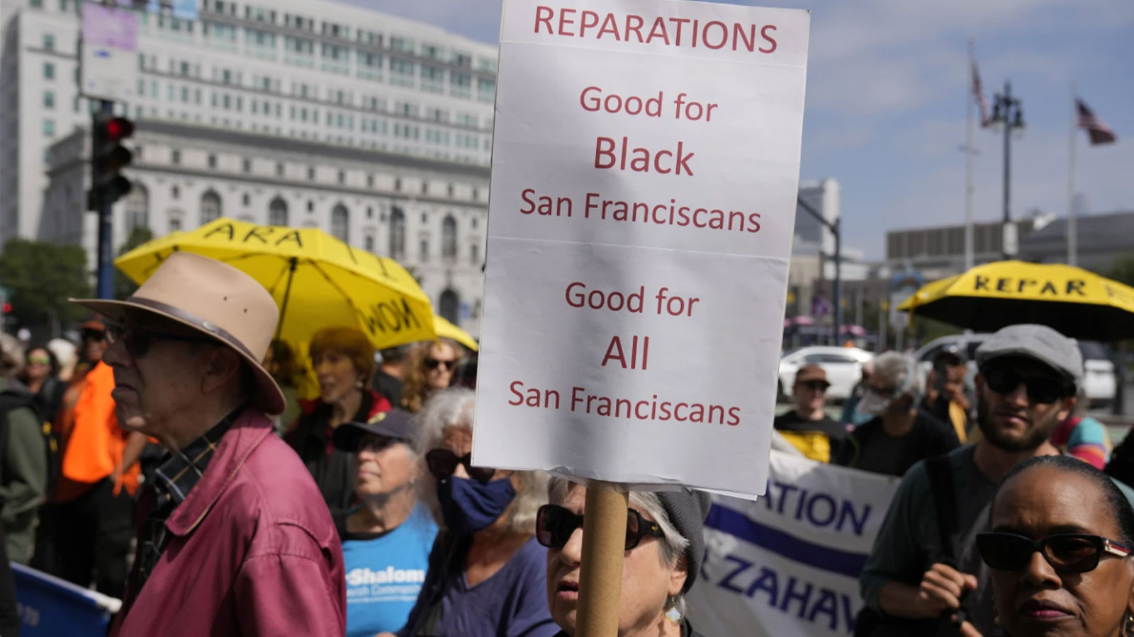 People listen during a rally in support of reparations for African Americans outside City Hall in San Francisco, Tuesday, Sept. 19, 2023.