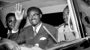 In this July 24, 1960 file photo, Congo Premier Patrice Lumumba waves as he sits in car for the drive from Idlewild Airport, New York after his arrival from Europe to speak to the United Nations Security Council.