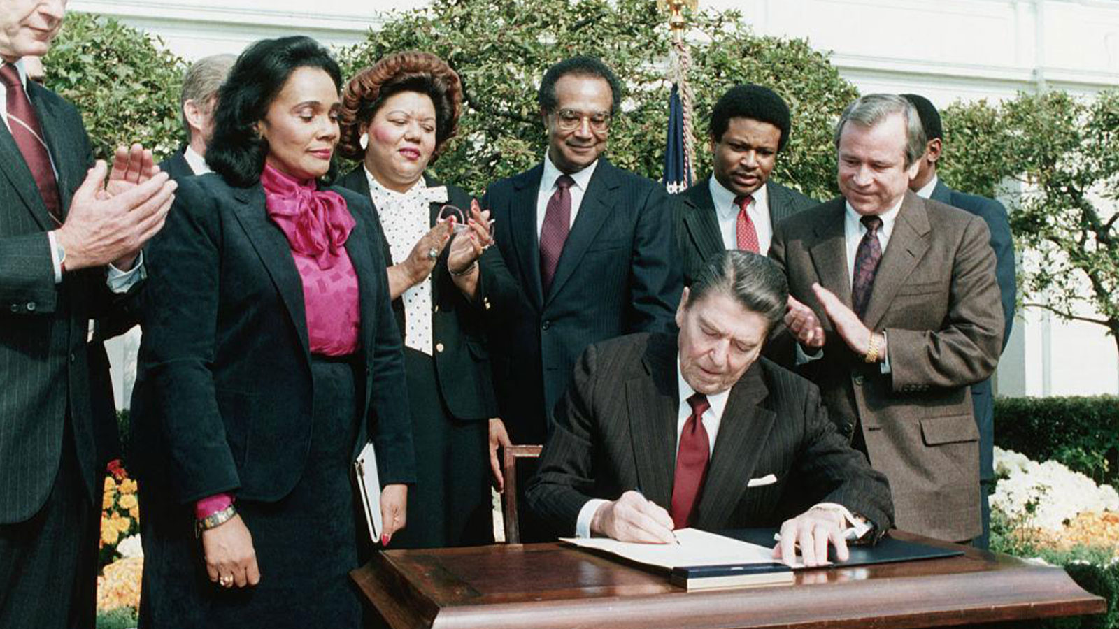 In the presence of Coretta Scott King (2nd from left), President Ronald Reagan signs a bill making Martin Luther King Jr.'s birthday a national holiday. 
