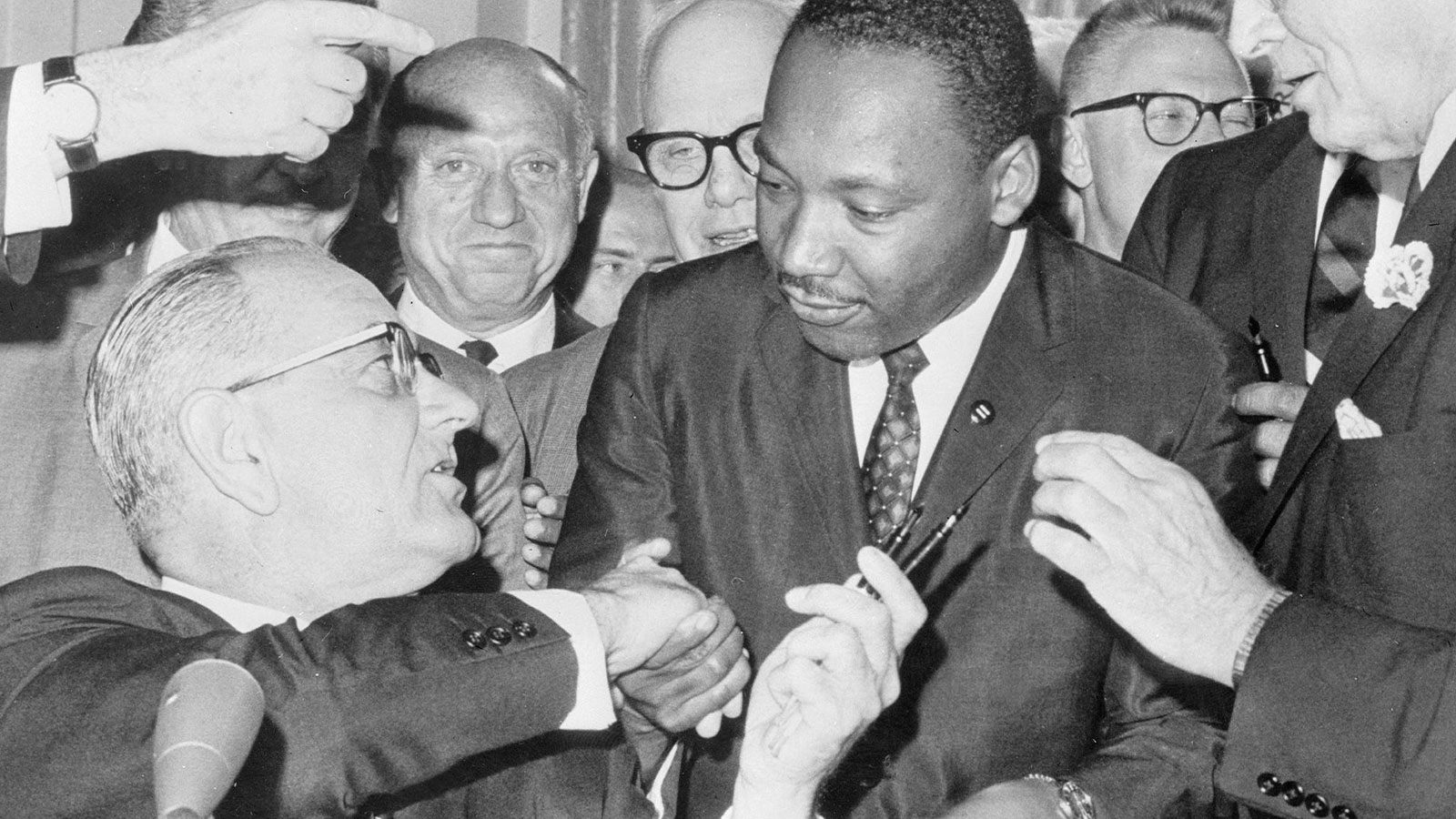 U.S. President Lyndon B. Johnson, left, shakes hands with Martin Luther King Jr. after signing the Civil Rights Act on July 3, 1964, at the White House. 