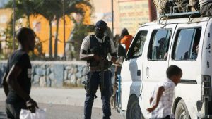 A police officer inspects a public transportation vehicle at a checkpoint in Port-au-Prince, Haiti. A court in Kenya blocked the deployment of a UN-backed police force to help fight gangs in the troubled Caribbean country.