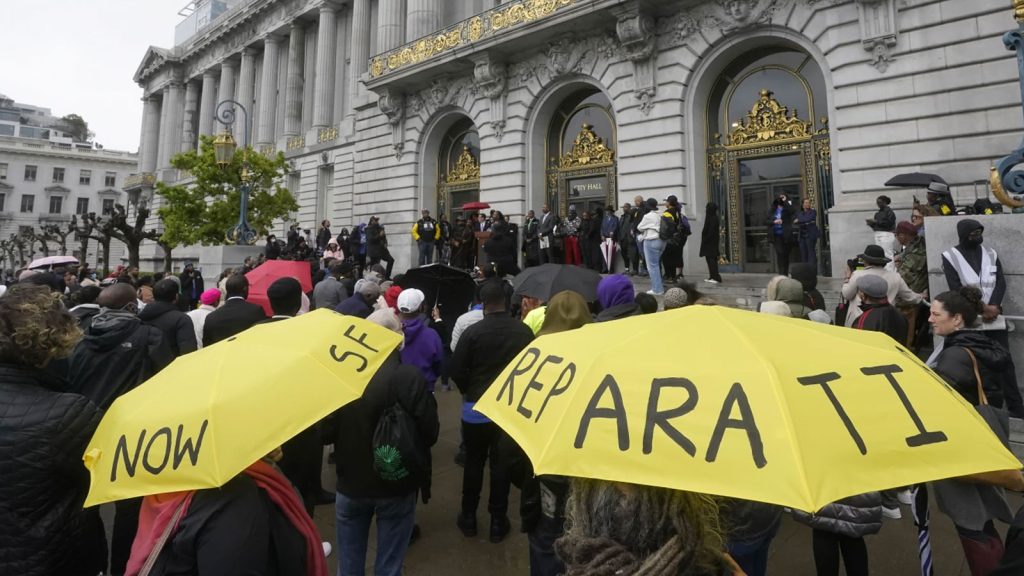 A crowd listens to speakers at a reparations rally outside of City Hall in San Francisco, on March 14, 2023. San Francisco's supervisors will offer a formal apology to Black residents for decades of racist laws and policies perpetrated by the city. All 11 supervisors have signed on as sponsors of an apology resolution to be voted on Tuesday, Feb. 27, 2024.