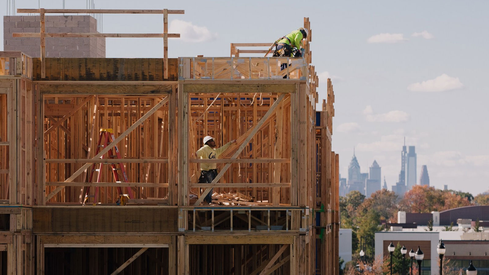 Construction workers in Cherry Hill, N.J., with the Philadelphia skyline in the distance.