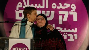 Israeli activist Yael Admi embraces Arab Israeli activist Ghadir Hani following a speech during a Dec. 28, 2023, demonstration in Tel Aviv organized by the group Standing Together.