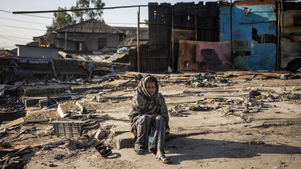 A woman sits among the debris of demolished buildings in the historic Piassa neighbourhood of Addis Ababa. A government redevelopment project is transforming the area, and people are being forced to move.